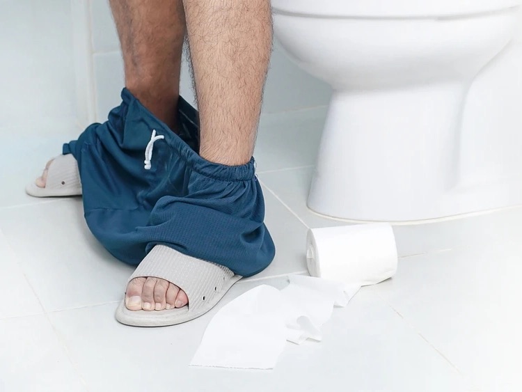 homme constipe sur les toilettes