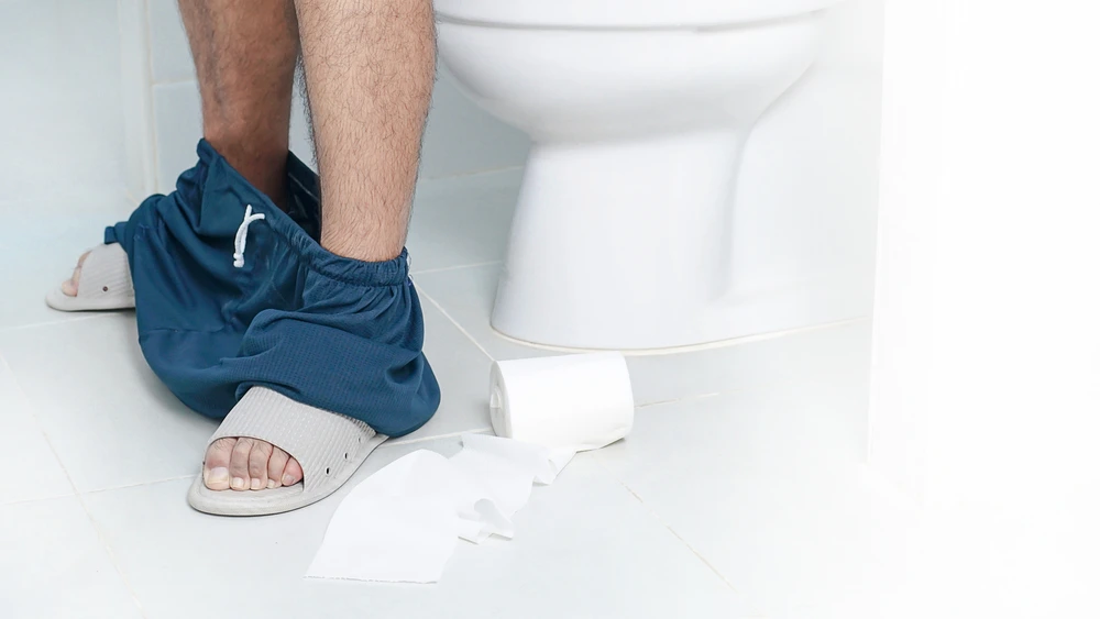 homme constipé aux toilettes